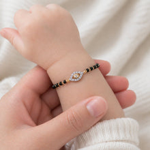 Load image into Gallery viewer, Baby's hand wearing a delicate bracelet with an eye design on a soft white background
