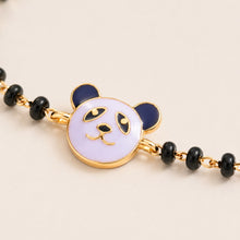 Load image into Gallery viewer, Bracelet with panda charm and black beads on a beige background
