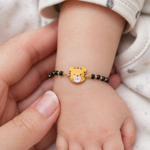 Load image into Gallery viewer, Child's wrist wearing a bracelet with a tiger face charm held by an adult hand.
